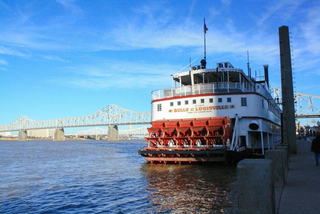 white and red ship on sea under blue sky during daytime