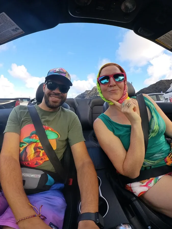Couple driving a convertible along the Hawaiian coast