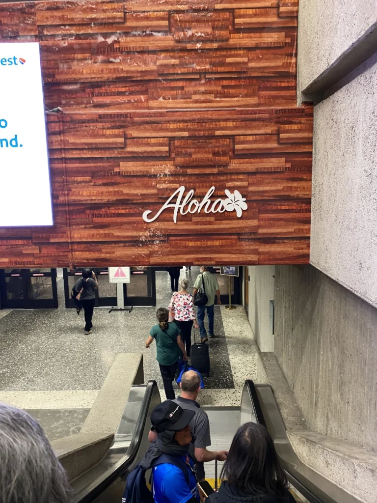 Arrival at Honolulu airport with the Aloha welcome sign after landing in Hawaii